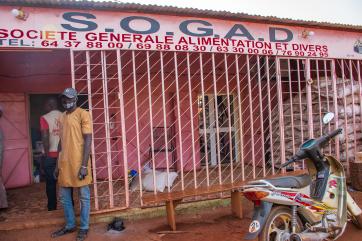 A person and a mercy corps agent outside the sogad store.