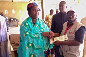 Malian woman receiving voucher.