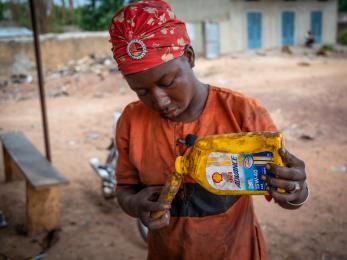 Participant pours oil into smaller container during justice and stability program in the sahel